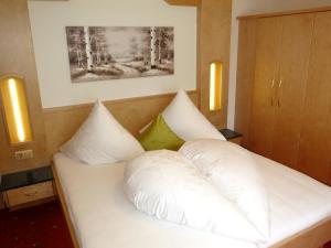 a bed with white pillows on it in a room at Haus Marita in Oetz