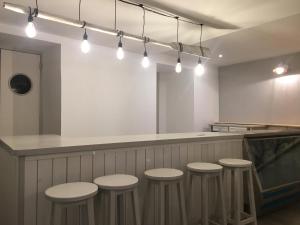 a bar with four stools and a counter with lights at Hostel Getaria in Getaria +2 photos