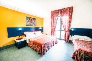 een hotelkamer met 2 bedden en een raam bij Hotel Raphael in Montecatini Terme