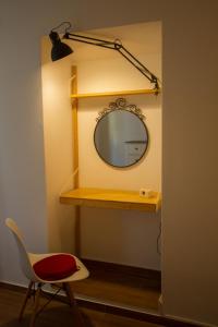 a mirror on a shelf with a chair and a lamp at Casa dos Avós in Villa Nogueira