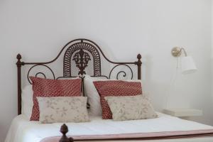 a bedroom with a bed with red and white pillows at Casa dos Avós in Villa Nogueira