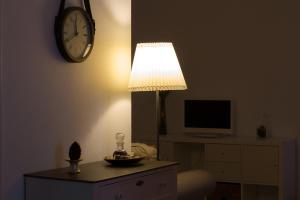 a room with a lamp and a clock on the wall at Casa dos Avós in Villa Nogueira