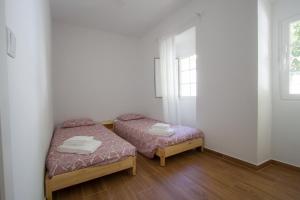 two beds in a small room with a window at Casa dos Avós in Villa Nogueira