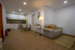a living room with a couch and a kitchen at Casa dos Avós in Villa Nogueira