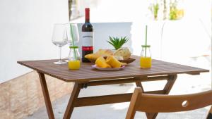 a wooden table with a plate of food and a bottle of wine at Casa dos Avós in Villa Nogueira +22 photos