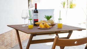 a wooden table with a plate of food and a bottle of wine at Casa dos Avós in Villa Nogueira