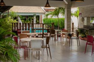 un restaurante con mesas y sillas y una piscina en Via Mar Praia Hotel, en Aracaju