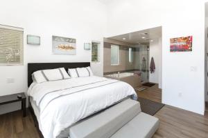 a white bedroom with a large bed and a bathroom at Venice Beach Gem in Los Angeles