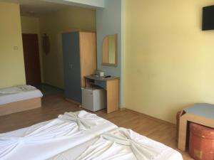 プリモルスコにあるArkadia Guest Houseのベッド2台とデスクが備わる客室です。