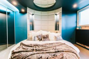 um quarto com uma cama grande e paredes azuis em Parenthèse Concept Room em Toulouse