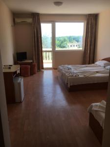 a hotel room with two beds and a large window at Arkadia Guest House in Primorsko