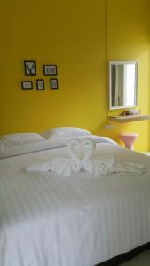 a white bed with a heart made out of towels at Patchy & PPraw Family in Ubon Ratchathani