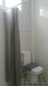 a bathroom with a toilet and a shower curtain at Patchy & PPraw Family in Ubon Ratchathani