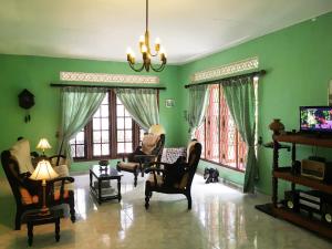 sala de estar con paredes y sillas verdes y TV en Wellington, en Hikkaduwa