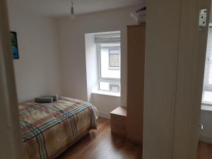 1 dormitorio con cama y ventana en 4 bed comfy house, cork, suit 7 guest max, en Cork