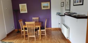 a dining room with a wooden table and chairs at Roadside Cottage The Burren in Kilfenora