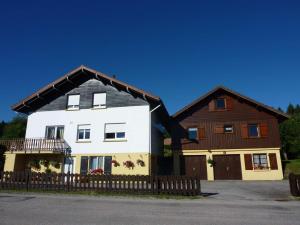 a large white and brown house with a fence at chalet trois étoiles in Xonrupt-Longemer