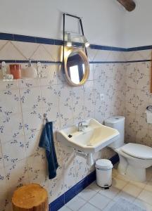 een badkamer met een wastafel, een toilet en een spiegel bij Casas Benali in Benali