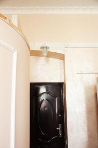 a black door in a hallway with a light above it at Apartment in the city center in Ivano-Frankivsʼk