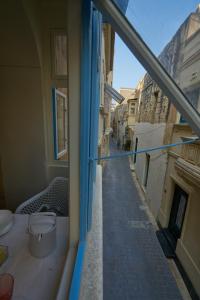 Blick auf eine Gasse vom Balkon eines Gebäudes in der Unterkunft Magic in the Heart of Old Gozo (First Floor) in Victoria