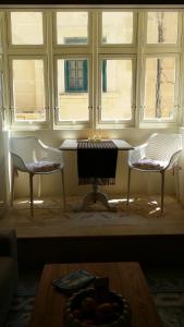 due sedie e un tavolo in una stanza con finestre di Magic in the Heart of Old Gozo (First Floor) a Victoria