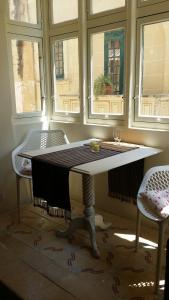 un tavolo in una stanza con due sedie e due finestre di Magic in the Heart of Old Gozo (First Floor) a Victoria