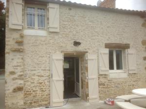 una casa remodelada con una puerta y ventanas en Le puit du lavoir en Thiré