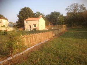 einen Zaun vor einem kleinen Haus in der Unterkunft Le puit du lavoir in Thiré