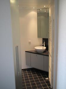een badkamer met een wastafel en een spiegel bij Malibu Beach in Koksijde