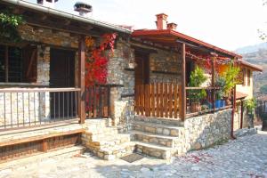 a stone house with a porch and a balcony at To Xani in Palaios Panteleimonas