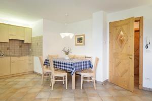 a kitchen and dining room with a table and chairs at Appartamento Boschetto Giulia in Carano