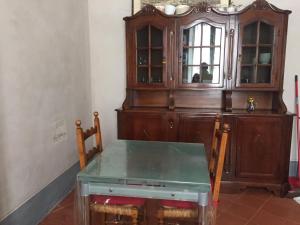 a dining room with a table and a cabinet at Almadelena Guest House in Pisa