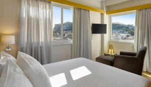 ein Hotelzimmer mit einem Bett, einem Stuhl und einem Fenster in der Unterkunft Acropolis View Penthouse in Athen