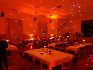 a banquet hall with tables and chairs and candles at Landgasthof Graf Karstädt in Karstädt