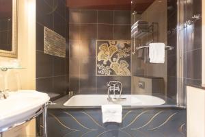 a bathroom with a tub and a sink at Hotel Du Beaumont in Paris +39 photos
