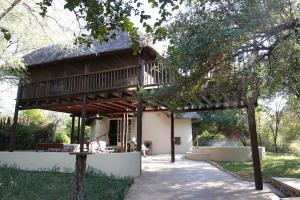 a house with a wooden roof and a patio at Treetops Marloth Park in Marloth Park