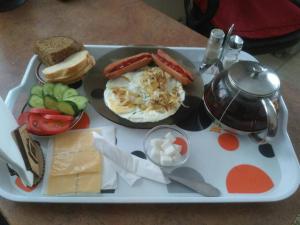 a tray with a breakfast of eggs sausage and bread and cheese at Guest House Orchid in Kropyvnytskyi