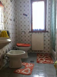 a bathroom with a toilet and a sink and a window at Terrazza Marsicana in Pescasseroli