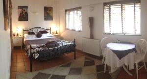 Schlafzimmer mit einem Bett, einem Tisch und Fenstern in der Unterkunft Tanglewood Gatwick Bed & Breakfast in Crawley