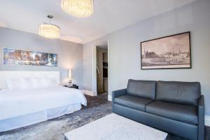 a bedroom with a bed and a couch at Hotel Manoir Morgan in Quebec City
