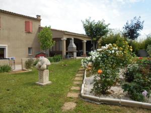 a garden with a statue in the yard of a house at chez lulu in Saint-Saturnin-dʼApt