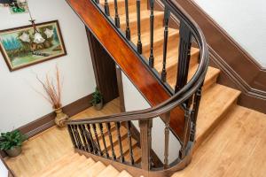 a wooden staircase with a wooden rail in a house at Almada Guest House in Porto