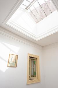 a room with a white wall and a blue ceiling at Almada Guest House in Porto