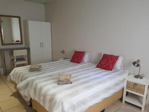 ein Schlafzimmer mit einem großen Bett mit zwei Handtüchern darauf in der Unterkunft Emerald Bed&Breakfast in Windhoek