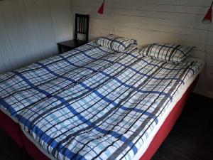 a bed with a blue and white blanket and pillows at Smelyan in Älvkarleby