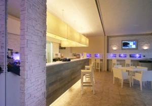 a restaurant with a bar with tables and chairs at Hotel Village Scoglio Della Galea in Capo Vaticano