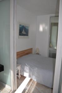 ラ・ロンド・レ・モールにあるCoquette Maisonnette Centre Ville La Londe Les Mauresのベッドルーム(白いベッド1台、鏡付)