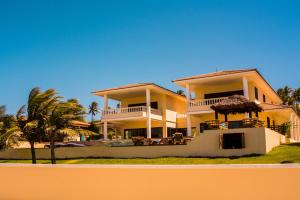 a large yellow house with a palm tree in front of it at Casa da Estrela in Barra do Cunhau