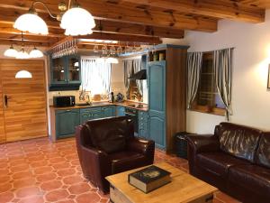 a living room with two leather chairs and a kitchen at Balaton Rustic Guesthouse in Badacsonytördemic