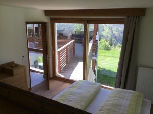 a bedroom with a large glass door with a balcony at Franzn Apartments in Petersberg